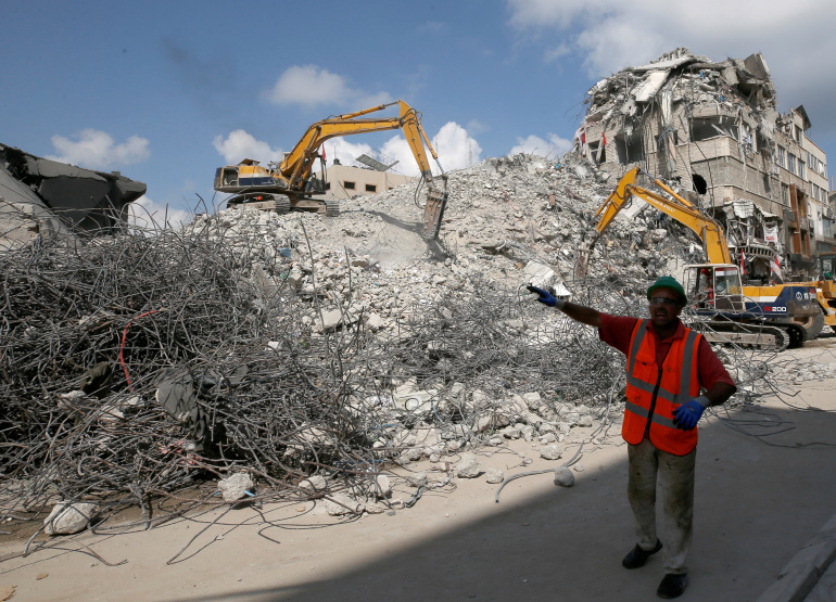 Bulldozers sent by Egypt for Palestinians work at the side of Israeli airstrikes in Gaza